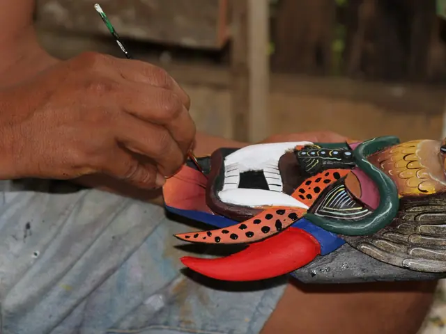 Artisan painting a carved Boruca mask